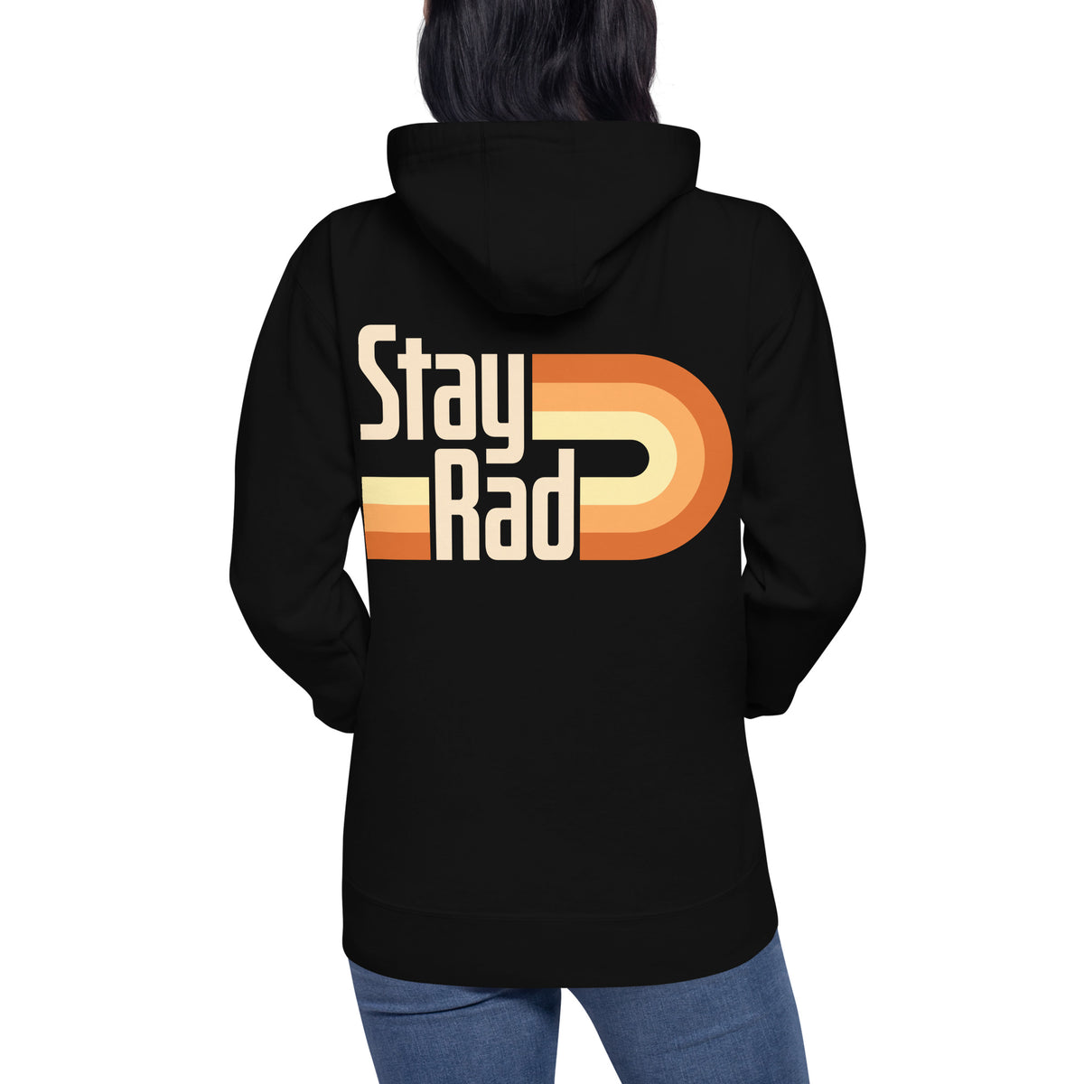A person shown from the back wearing a black hoodie with a large retro-style 'Stay Rad' graphic in cream, yellow, and orange on the back, paired with blue jeans against a plain white background.