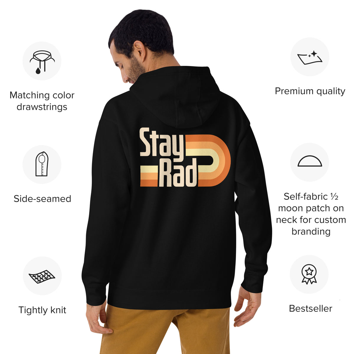 A man shown from the back wearing a black hoodie with a large retro-style 'Stay Rad' graphic in cream, orange, and yellow on the back. The image includes feature callouts around the model on a white background.
