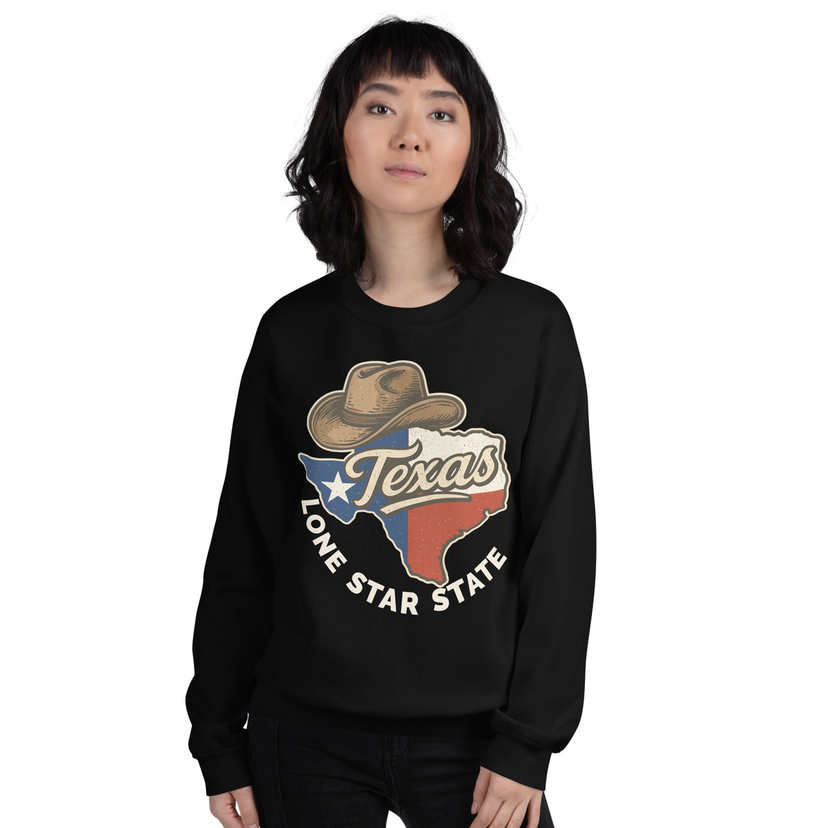 A woman modeling a black crewneck sweatshirt with a Texas-themed graphic on the front, featuring a cowboy hat, the word 'Texas', and the text 'Lone Star State' over a red, white, and blue state outline. The background is solid white.