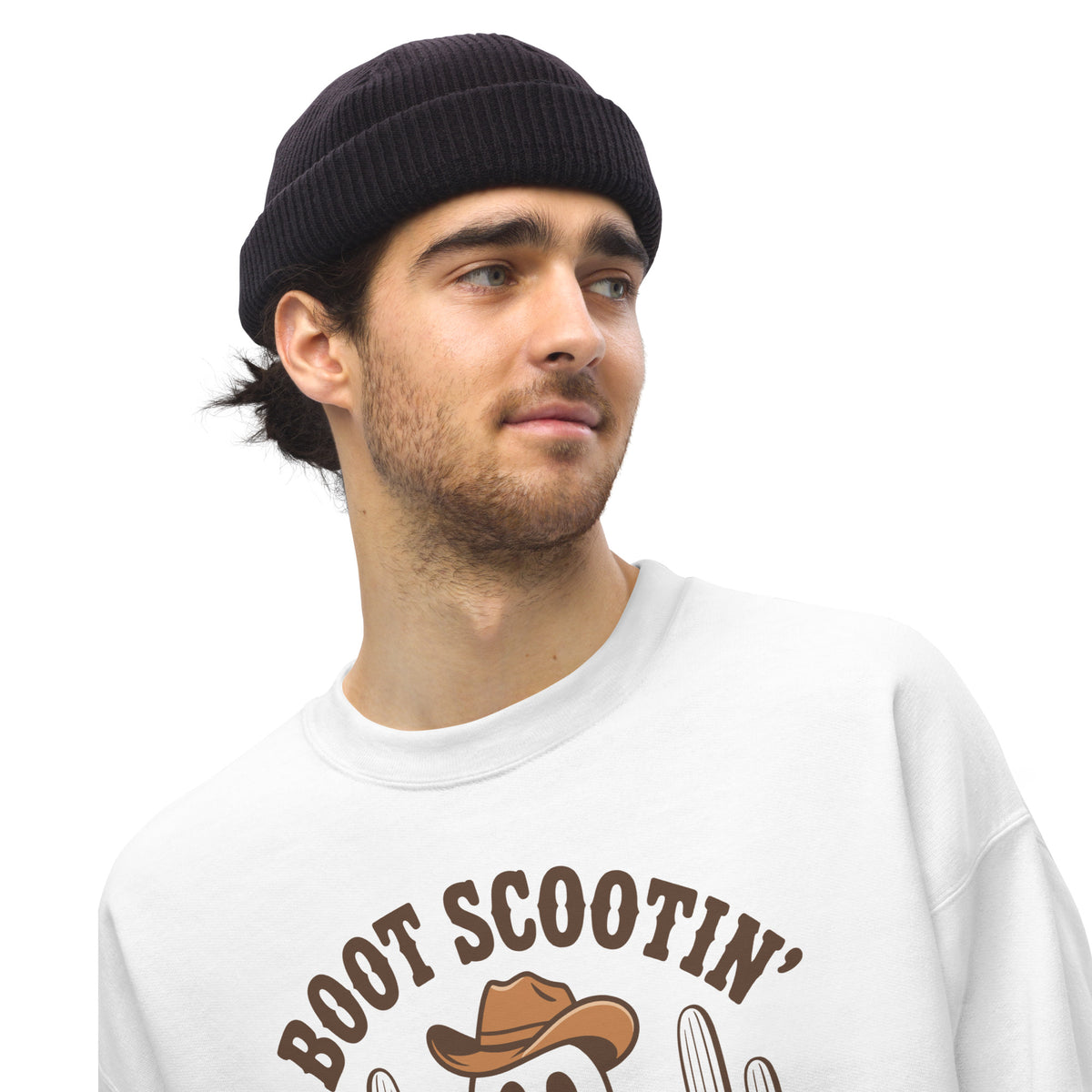 A man wearing a black ribbed beanie and a white crewneck sweatshirt with a brown 'BOOT SCOOTIN'' graphic featuring a cowboy hat and cactus, set against a plain white background.