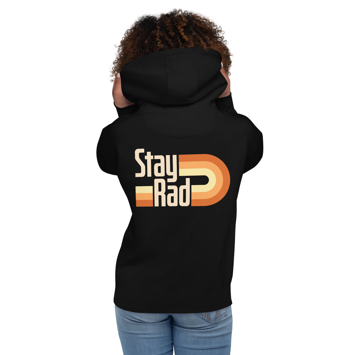 A child shown from the back wearing a black hoodie with a retro-style 'Stay Rad' graphic in cream, beige, and orange on the back, paired with blue jeans against a plain white background.