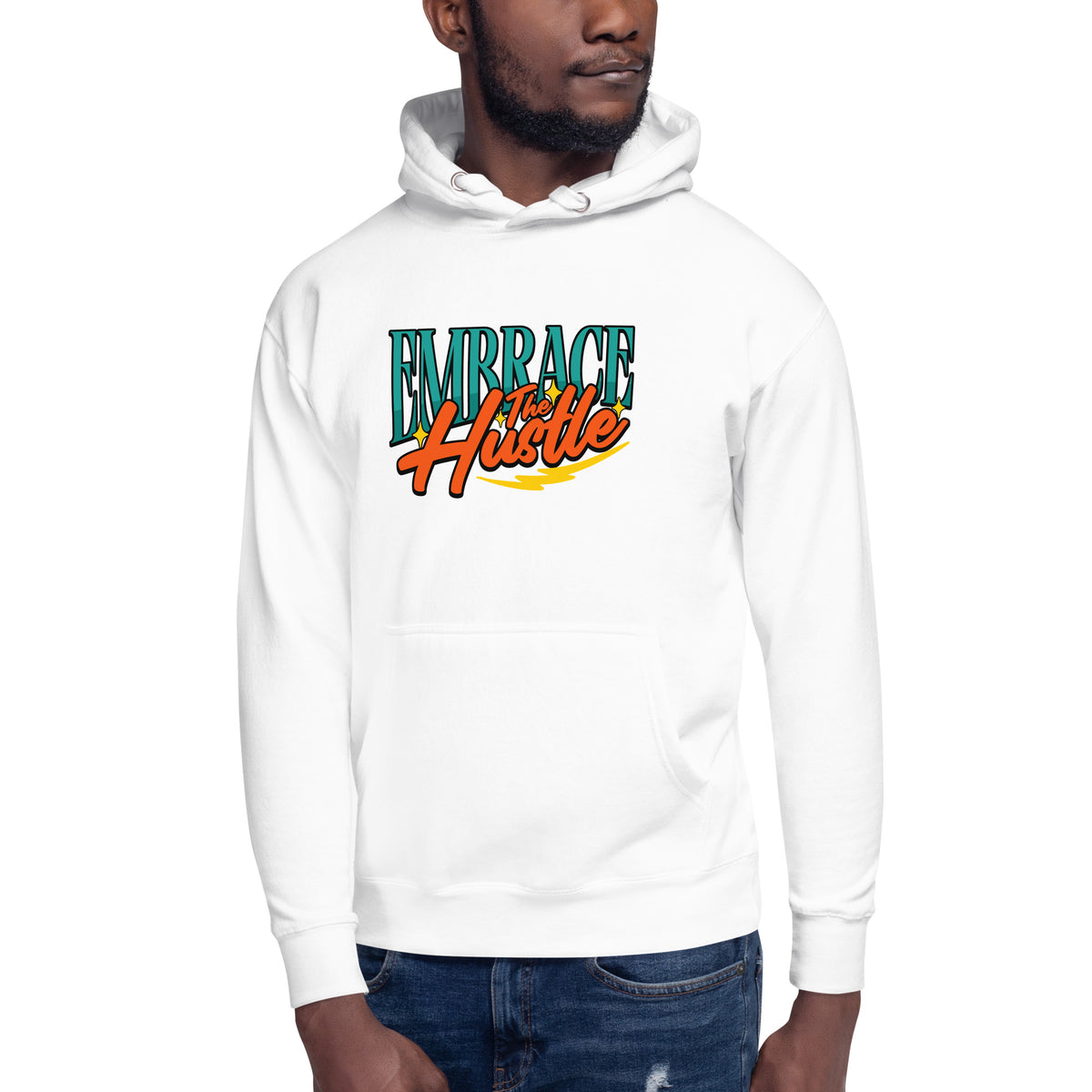 A man wearing a white pullover hoodie with a colorful graphic on the chest that reads 'EMBRACE the Hustle' in teal, orange, and yellow, paired with blue jeans against a plain white background.