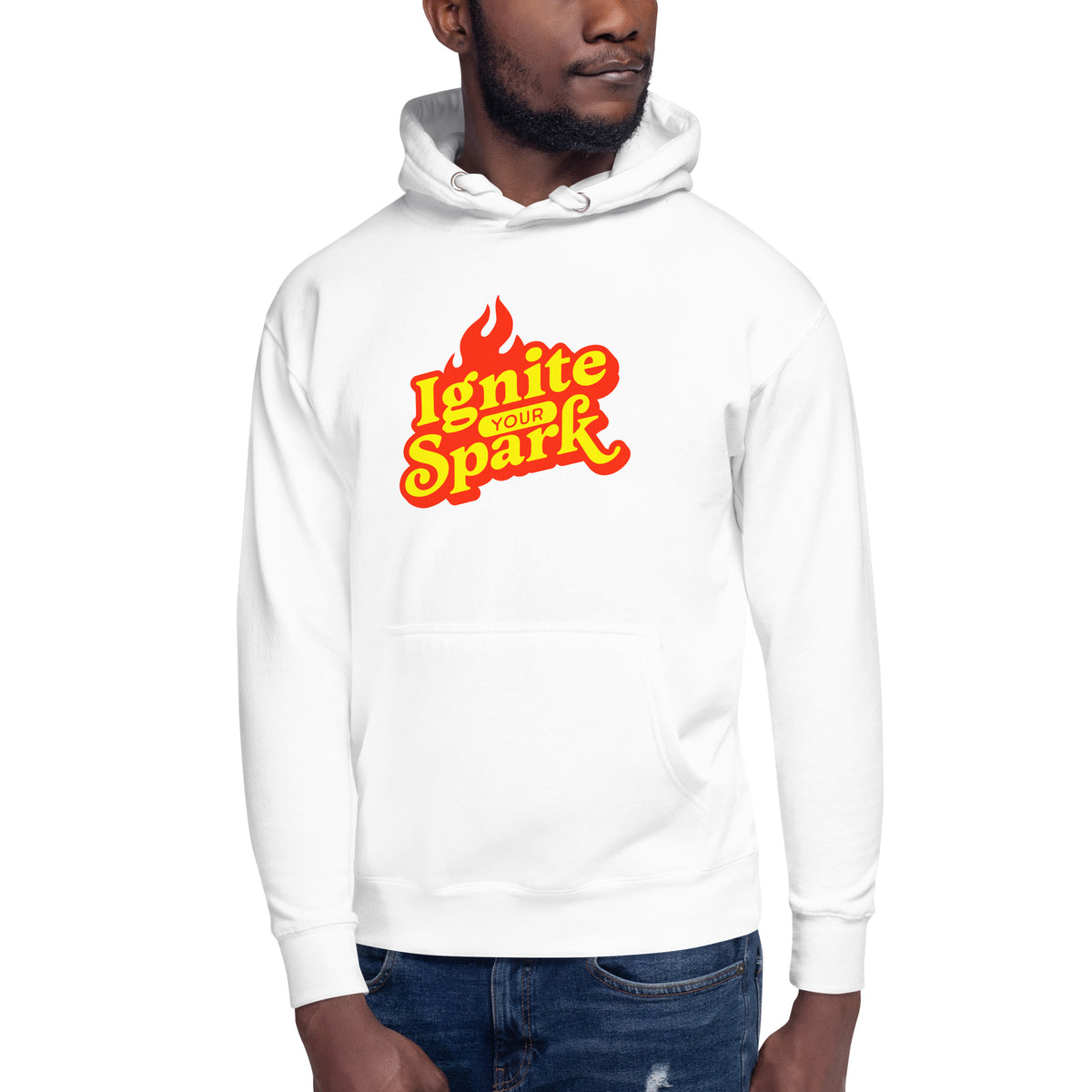 A man wearing a white pullover hoodie with a bold red and yellow 'Ignite with Spark' graphic on the chest, paired with blue jeans, against a plain white background.