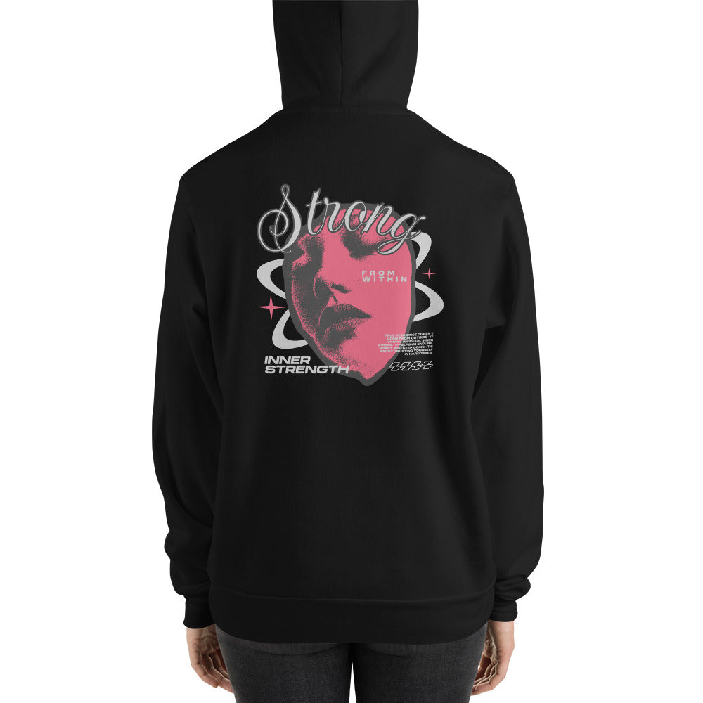 A person shown from the back wearing a black hoodie with a large graphic print on the back. The design features a pink heart shape with a stylized face inside, white decorative text reading 'Strong', and smaller white text elements, all on a plain white background.
