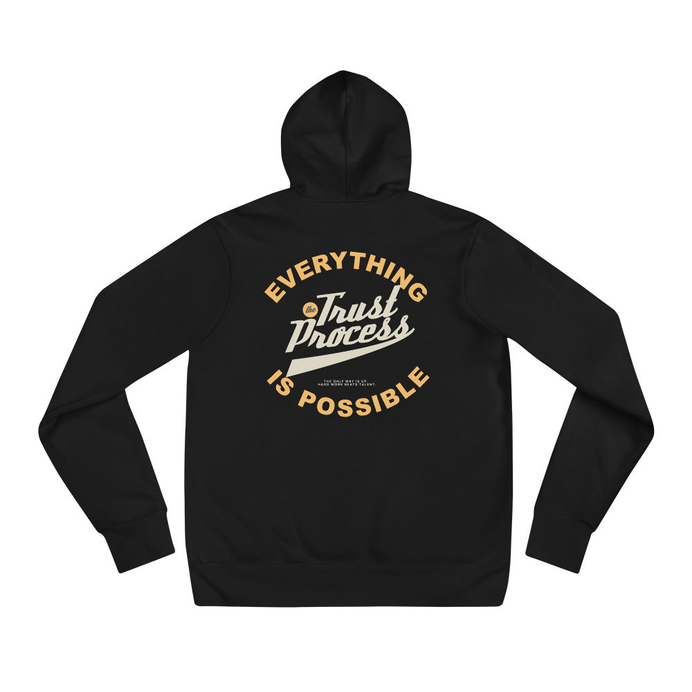 A black zip-up hoodie shown from the back, featuring a graphic print that reads 'EVERYTHING Trust Process IS POSSIBLE' in gold and white lettering, on a plain white background.