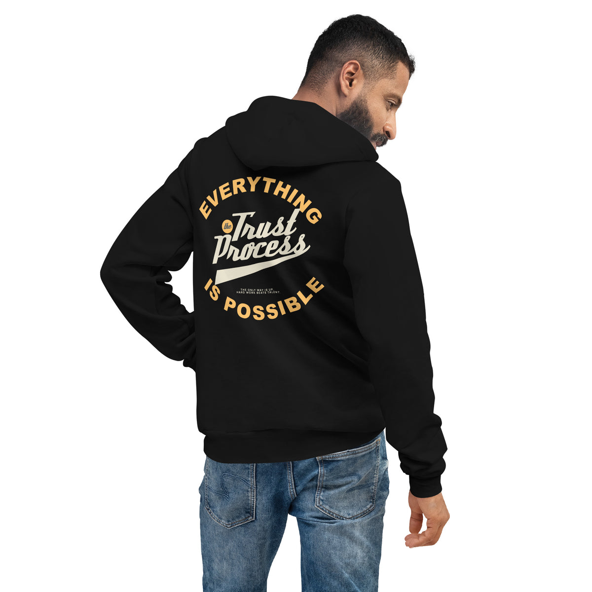 A man wearing a black hoodie from the back, showing a large graphic print on the back that reads 'EVERYTHING Trust Process IS POSSIBLE' in yellow and white. He is wearing blue jeans against a plain white background.