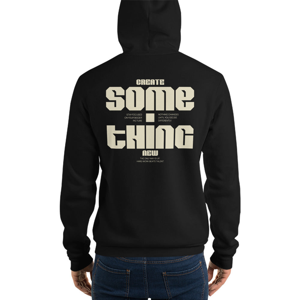 A person shown from the back wearing a black hoodie with large cream text reading 'CREATE SOME THING NEW' across the back, paired with blue jeans on a plain white studio background.
