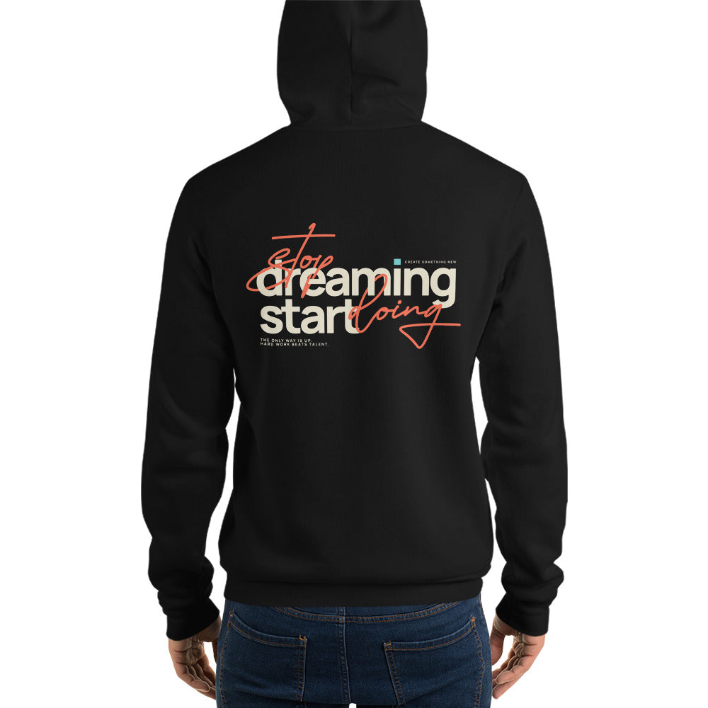 A person shown from the back wearing a black hoodie with a large graphic on the back that reads 'stop dreaming start doing' in white and orange-red lettering, paired with blue jeans, against a plain white background.
